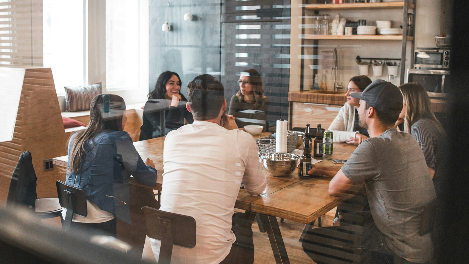 team-mates-sitting-at-table-and-talking. Credit: redd-francisco-5U_28ojjgms-unsplash
